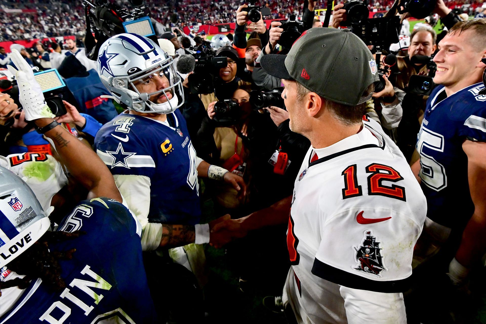 Dak Prescott of the Dallas Cowboys and Tom Brady of the Tampa Bay Buccaneers embrace on the field